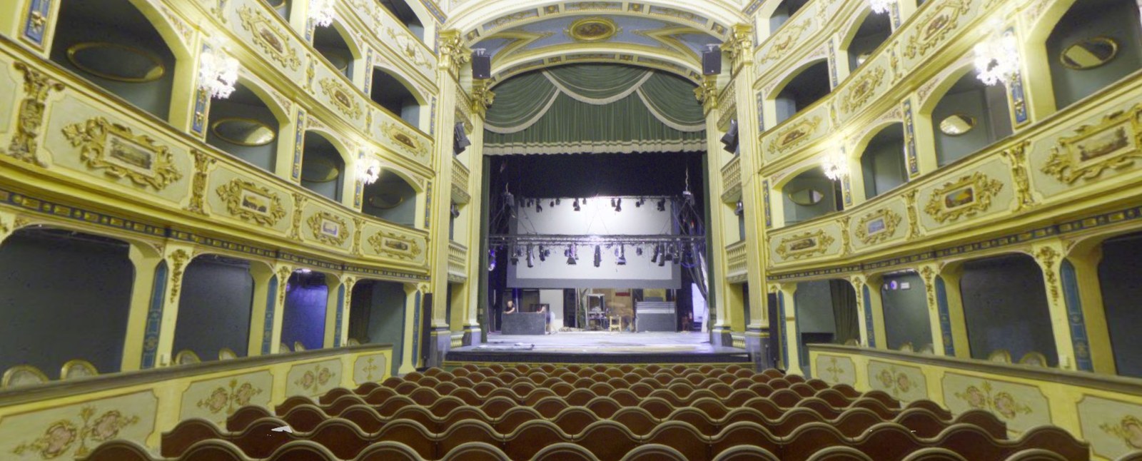 Point cloud of a historic theatre auditorium looking towards the lit stage from the tiered boxes